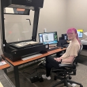 Image of student employee Madison Northup seated at book scanner. 